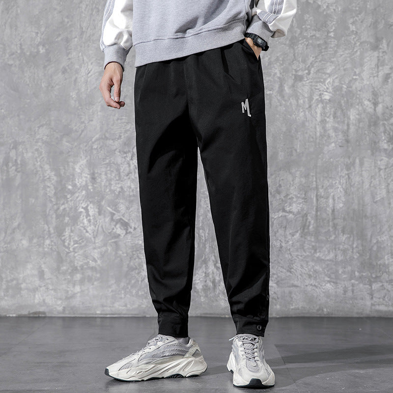 Men's Utility Cargo Pants - model wearing black tapered pants with white sneakers