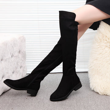 Women's Over-the-Knee Flat Boots - black boots with low block heels worn by a seated model