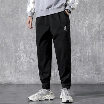 Men's Utility Cargo Pants - model wearing black tapered pants with white sneakers